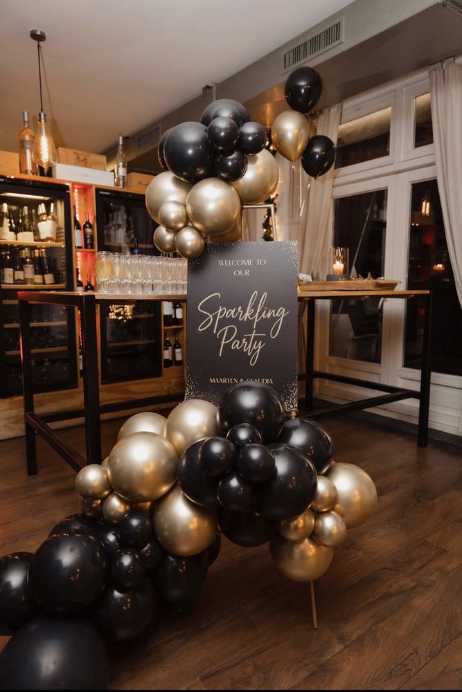 Zwart-gouden ballonnenboog met welkomstbord Sparkling Party